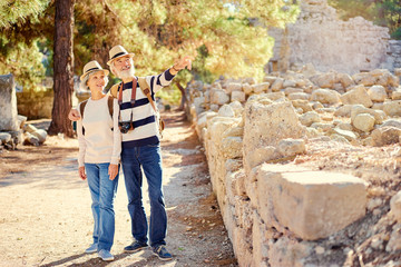 Obraz na płótnie Canvas Travel and tourism. Senior family couple walking together on ancient sighseeing.