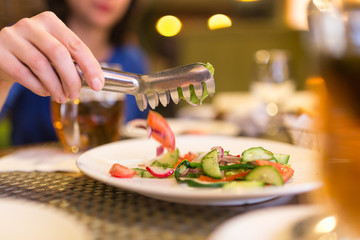 Girl eating a dish with tomatoes and cucumbers