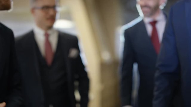 Smart professional business team walking through office, close up on handshake