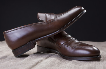 Shoes Concepts and Ideas. Closeup of Stylish Modern Brown Leather Penny Loafer Shoes Against Black Background