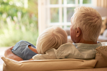 Content senior couple relaxing together on their sofa at home