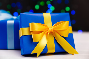 Gift boxes on blurred background. Presents wrapped with paper, bow and ribbons. Christmas or...