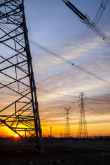 The silhouette of the evening electricity transmission pylon