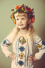 Closeup image of little beautiful girl in embroidered clothes