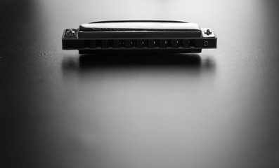 Harmonica isolated on black background. Black and white photography.