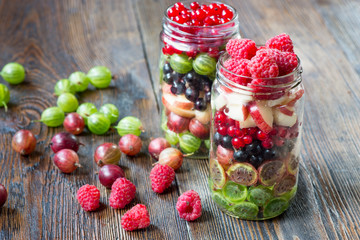 Summer berries smoothie in mason jar on rustic wooden table