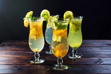 Set lemonade with ice in glass hurricane with tropical fruits