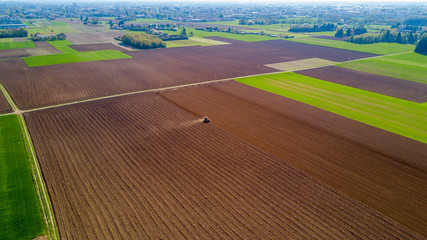 Trattore che ara i campi, vista aerea, arare, seminare, raccogliere. Agricoltura e coltivazione, campagna  © Naeblys