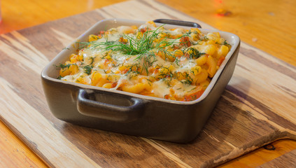 Macaroni or pasta with cheese and meat in square dish. Warm dish from the owen. Close up / macro photography.