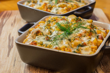 Macaroni or pasta with cheese and meat in square dish. Warm dish from the owen. Close up / macro photography.