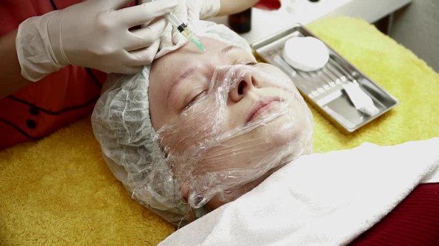 Beautician making injections for the woman