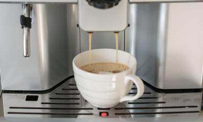 Close-up of espresso pouring from coffee machine. Professional coffee machine. Office. 
