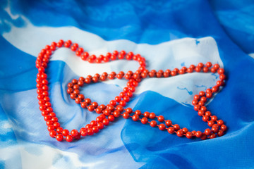 Two hearts of beads on a background of blue silk