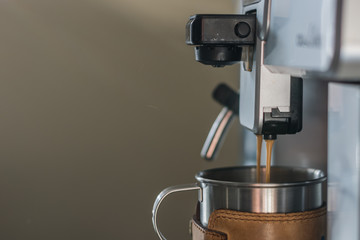 Close-up of espresso pouring from coffee machine. Professional coffee machine. Office. Black and white.