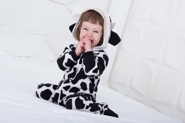 Baby in cow costume in white interior