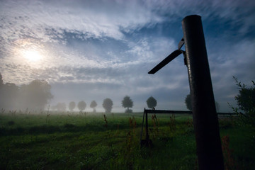 Night field landscape. Fog over the meadow. Full moon shine.