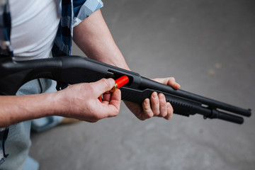 Professional skilled marksman loading his gun