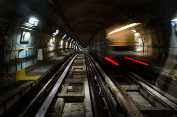 Metro subway of Turin (Italy) with dark tunnel and a train moving fast