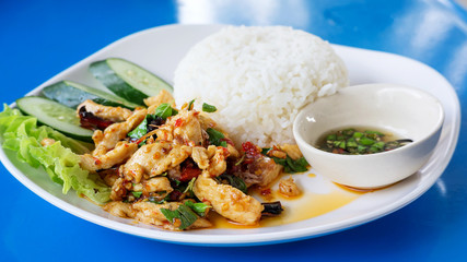 Spicy fried chicken with basil leaves and steamed rice.
