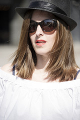 Young and trendy hipster woman is standing and watching something. Lifestyle concept.