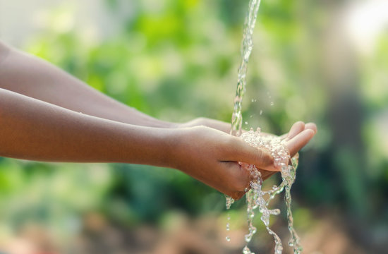 Water pouring in kid two hand on nature background