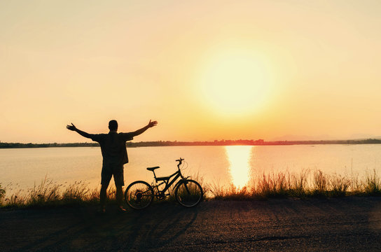 silhouette human freedom of cyclist in nature background and beautiful sunset