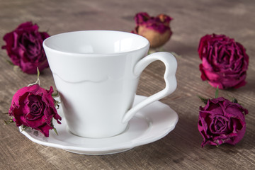 Coffee cup and dry buds of roses