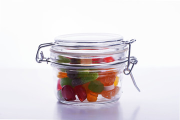 Jar filled with sausages on white background.