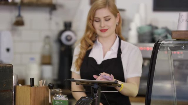  Portrait of friendly smiling worker standing behind counter in coffee shop