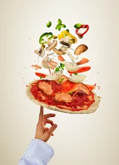 Photo sur Plexiglas Pizzeria Chef préparant une pizza avec des ingrédients volants