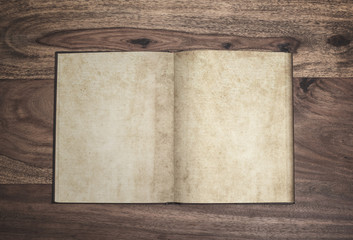 open plain page vintage book with stained yellowed paper on rustic wooden surface