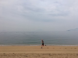 Man running on empty sandy beach