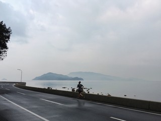 Runner on island road beside sea