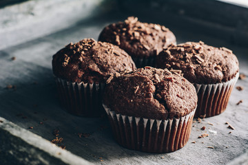 Chocolate muffins on gray wooden tray
