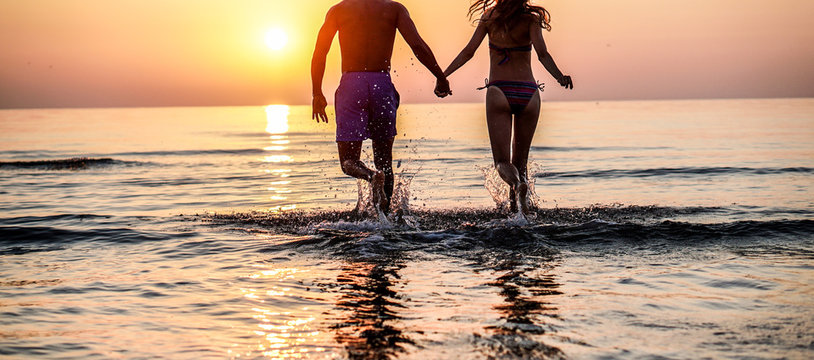 Couple of lovers running on the beach in tropical place for summer vacation