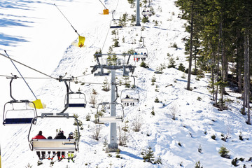 Chair ski lift elevator lifting people on the mountain ski slope Bansko Bulgaria ski centre 
