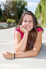 lovely brunette woman lying on the park in summer day