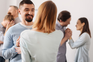 Obraz premium Positive delighted man standing opposite his colleague