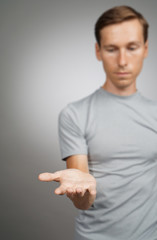 Man holding something blank in his hand on a grey background.