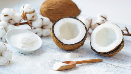 Still life with coconut, coconut flakes and white cotton flowers, healthy organic food concept