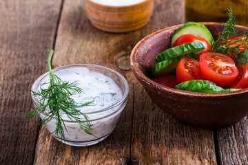 Yogurt sauce with dill and tomato cucumber salad