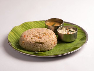 godhuma rava upma with sambar and coconut chutney served in a banana leaf on white background