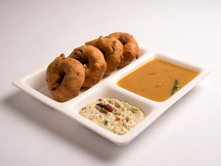medhu vadai (Ulundu vadai) with sambar and chutney served in a white plate on white background