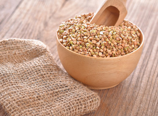 Buckwheat isolated in wooden bowl on table