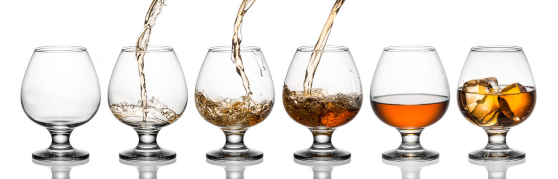 Glasses with whiskey or brandy isolated on white background
