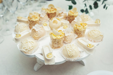 Obraz na płótnie Canvas white Cakes and cupcakes on vintage white dish
