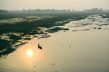 Life of India : Fishing boat in a sunset river