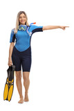 Woman in a wetsuit with snorkeling equipment pointing right