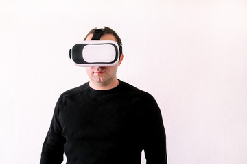 Man using a virtual glasses on white background. Young male business executive using virtual reality headset in office. Gays at office and using virtual reality glasses.