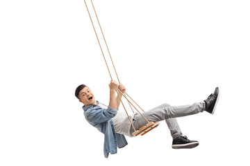 Joyful teenager swinging on a swing - obrazy, fototapety, plakaty